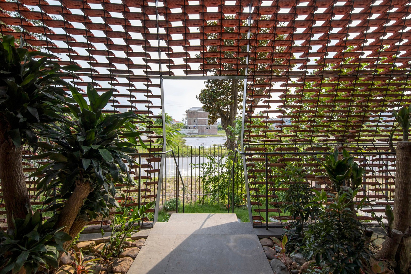 Lớp ngói và lớp cây xanh lồng vào nhau có chức năng hoạt động như bộ lọc nhằm triệt tiêu những yếu tố bất lợi của môi trường bên ngoài (nắng nóng hướng Tây, khói bụi, tiếng ồn) và đưa thiên nhiên (ánh sáng, mưa, gió) vào những nơi cần thiết bên trong.