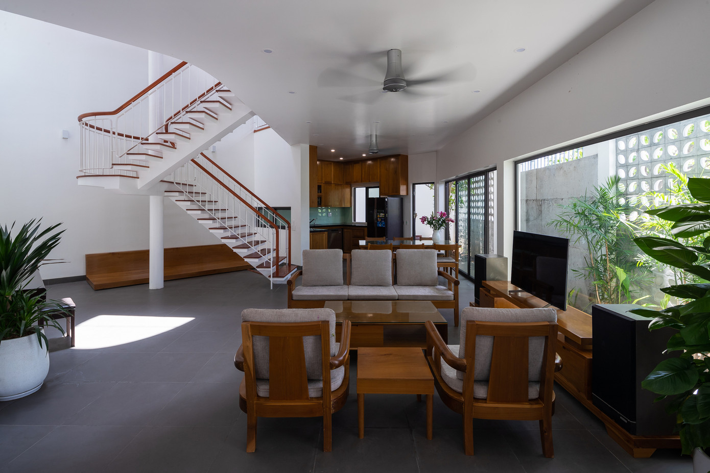 Không gian bếp, ăn, khách có cảm giác mở, thoáng từ bên trong. Không gian đệm này cũng là nơi đối lưu không khí vừa có tác dụng che chắn vừa làm mát không gian bên trong. Tầng 2 và 3 có ban công nhìn ra sân vườn, nơi gia đình có thể thư giãn.