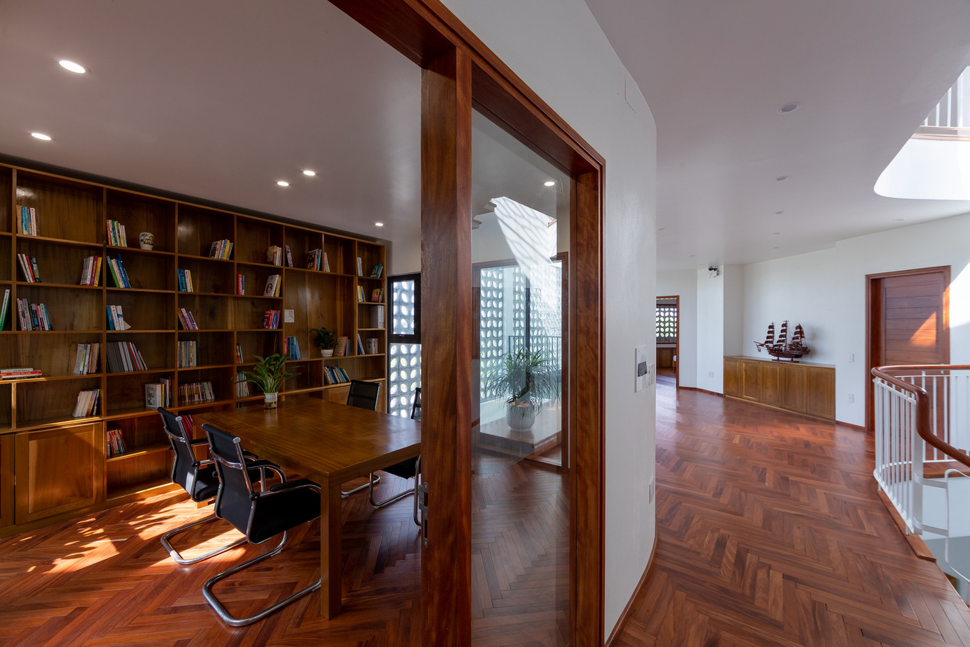 Một góc vườn giếng trời hình tam giác được tạo sự liên thông với khu vực bếp ăn ở tầng 1 trong khi khu vườn có thể được tiếp cận thông qua một hành lang đệm không gian hẹp dài mà không cần đi vào nhà.