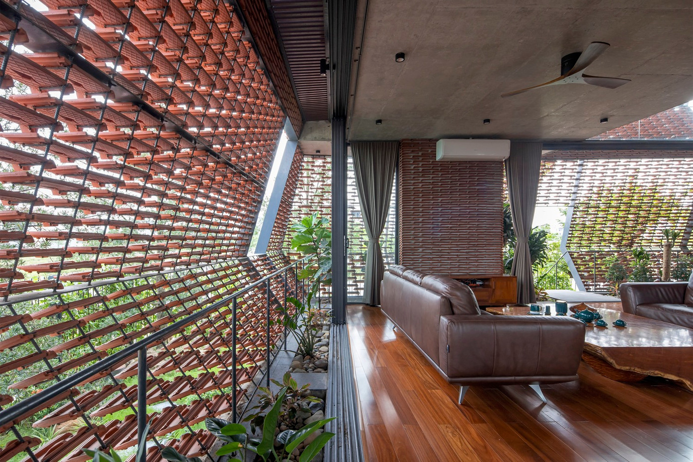 Sự kết hợp giữa các yếu tố mang lại cho kiến trúc ngôi nhà một diện mạo gợn sóng khác biệt, với lớp vỏ xốp/đục lỗ ở bên ngoài và một không gian rộng rãi ở bên trong.