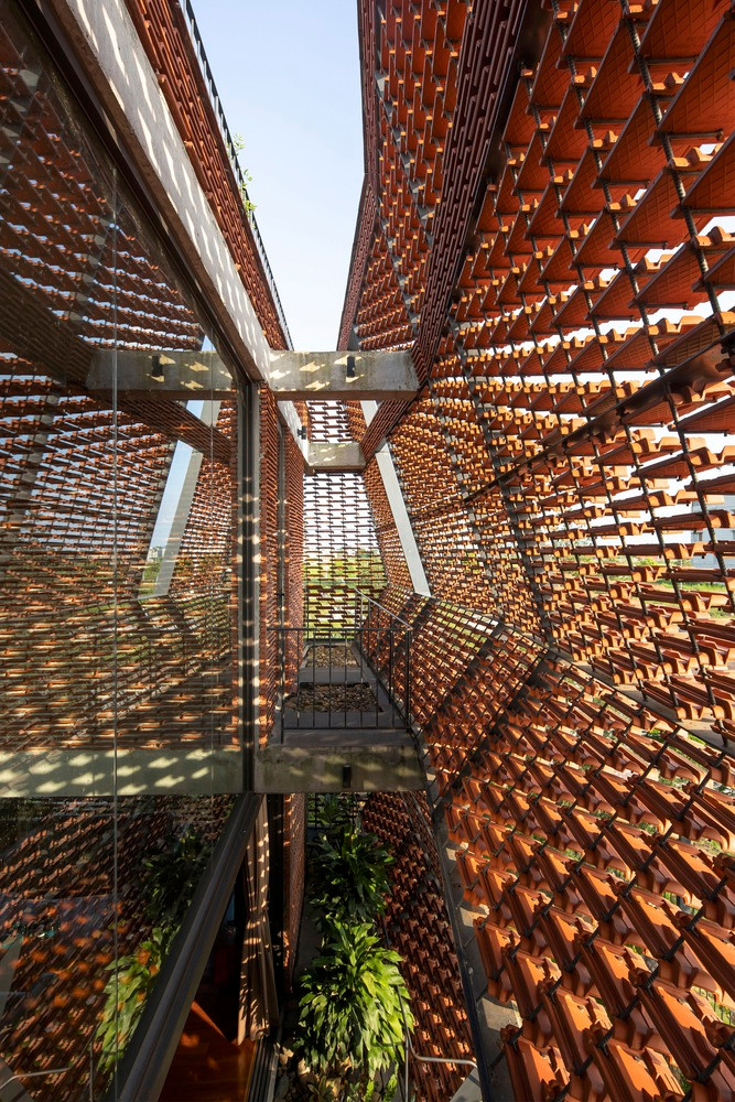 Vỏ ngoài của ngôi nhà được ghép từ nhiều viên ngói lơ lửng như đang bay (gợi liên tưởng đến mái chồng ngói, che nắng như ở nếp nhà truyền thống,..).