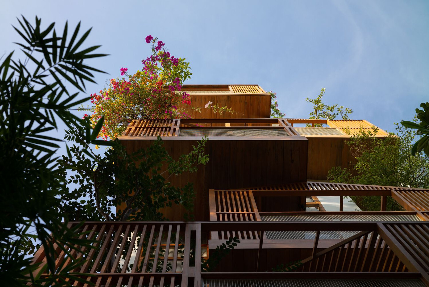 Hệ thống lam gỗ và cây xanh phía trước tòa nhà được điều chỉnh và tính toán kỹ lưỡng nhằm giảm thiểu lượng bụi, khói và tiếng ồn từ tuyến phố chính sầm uất, đồng thời tránh được ánh nắng trực tiếp từ hướng Tây. Hệ thống lam gỗ và cây xanh phía trước tòa nhà được điều chỉnh và tính toán kỹ lưỡng nhằm giảm thiểu lượng bụi, khói và tiếng ồn từ tuyến phố chính sầm uất, đồng thời tránh được ánh nắng trực tiếp từ hướng Tây.