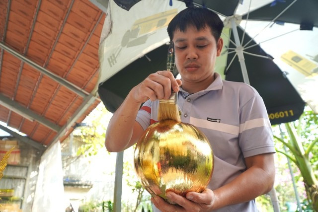 Công đoạn dát vàng gồm các bước: Quét keo lên dừa và để khoảng 40 – 45 phút cho keo khô, sau đó dát vàng lên. Khi dát vàng xong, lấy cọ chuyên dùng để quét đều lá vàng và khâu cuối là trang trí theo mẫu tự thiết kế. Mất 1-2 giờ để hoàn thành 1 cặp dừa dát vàng.