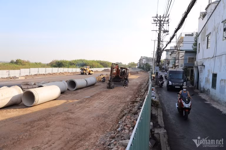 Phía sau rào chắn bằng tôn (sát đường C12) là công trường thi công đoạn cuối tuyến đường nối Trần Quốc Hoàn - Cộng Hòa đang rầm rộ. Một phần tuyến đường nối đã được lộ diện.