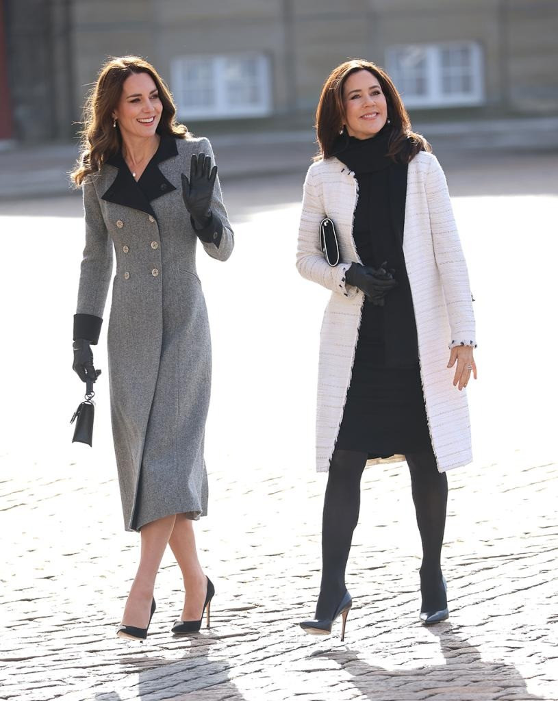 Khi tiếp đón Công nương Kate đến thăm Đan Mạch vào năm 2022, Hoàng hậu Marry diện chiếc áo khoác vải tuýt màu trắng sang trọng bên ngoài váy đen và quần tất tối màu. Vẻ ngoài giản dị vừa khác biệt lại đồng điệu với Vương phi xứ Wales. Ảnh: Getty Images.