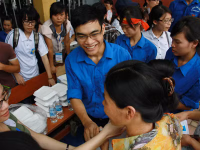 Sinh viên tình nguyện phát cơm miễn phí cho các sĩ tử. Ảnh: Trường Phong