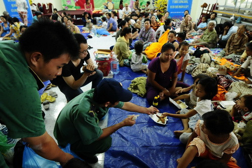 Lực lượng thanh niên xung phong được tăng cường từ các quận phát cơm miễn phí cho bà con xã đảo Thạnh An vào đất liền tránh bão - Ảnh: Thuận Thắng/Tuổi trẻ 