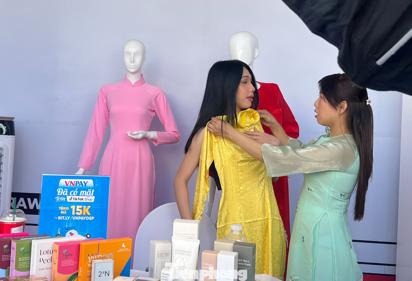 Chị Phan Thị Lài (bìa phải), tiểu thương chợ Bến Thành livestream giới thiệu áo dài.