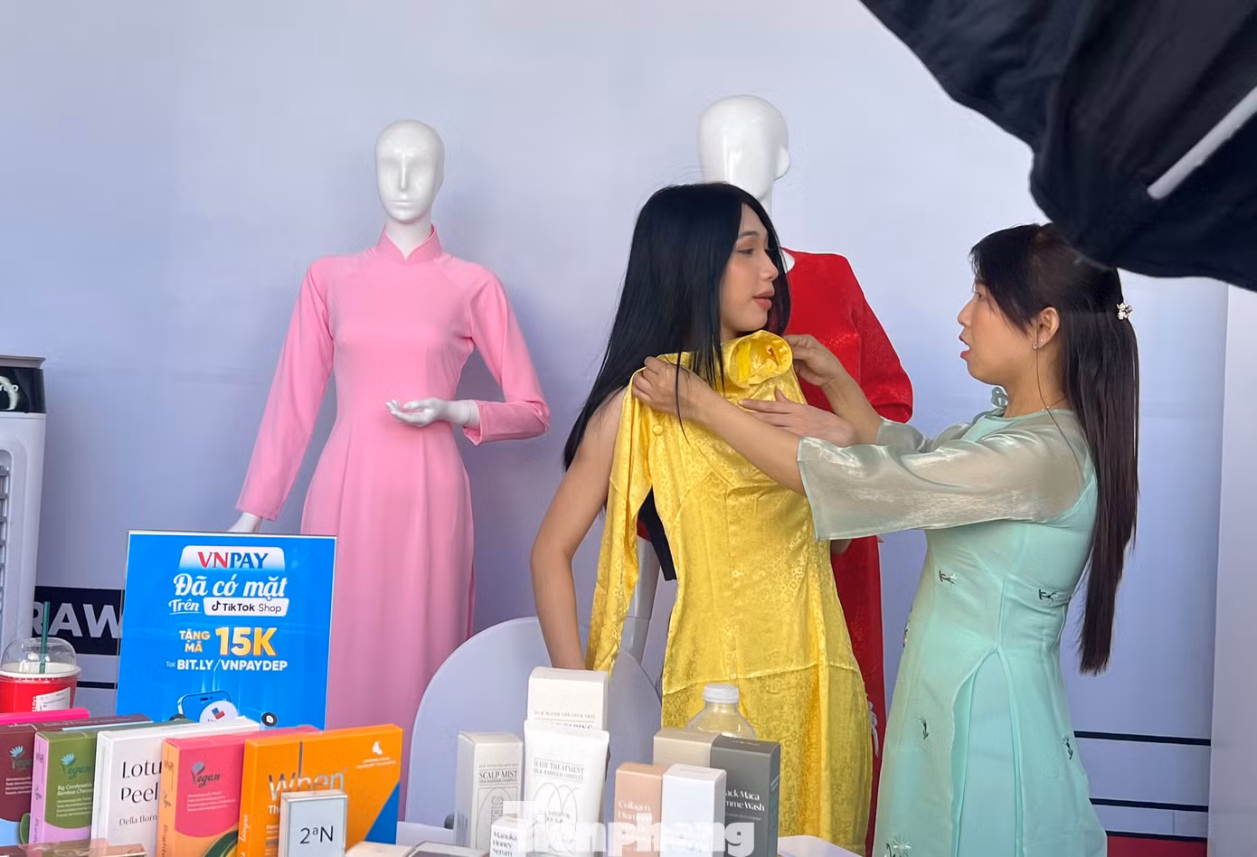 Chị Phan Thị Lài (bìa phải), tiểu thương chợ Bến Thành livestream giới thiệu áo dài. Chị Phan Thị Lài (bìa phải), tiểu thương chợ Bến Thành livestream giới thiệu áo dài.