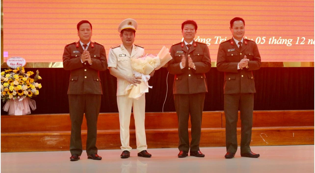 Thượng tá Lê Phi Hùng (thứ hai từ trái sang) nhận hoa chúc mừng của Ban giám đốc Công an tỉnh Quảng Trị.