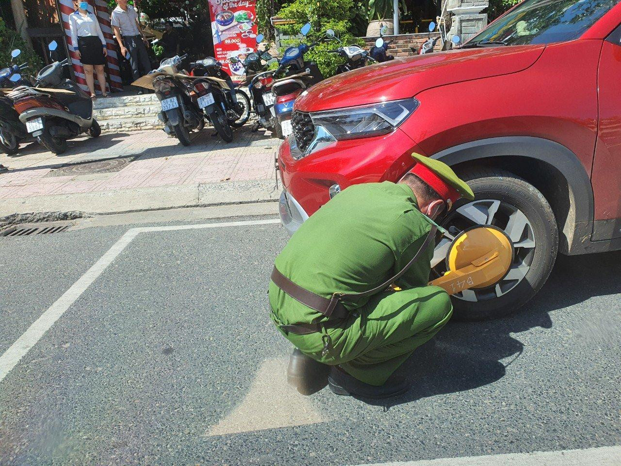 Công an TP. Nha Trang khoá bánh xe ô tô vi phạm quy định đậu trên đường. Ảnh L.H Công an TP. Nha Trang khoá bánh xe ô tô vi phạm quy định đậu trên đường. Ảnh L.H