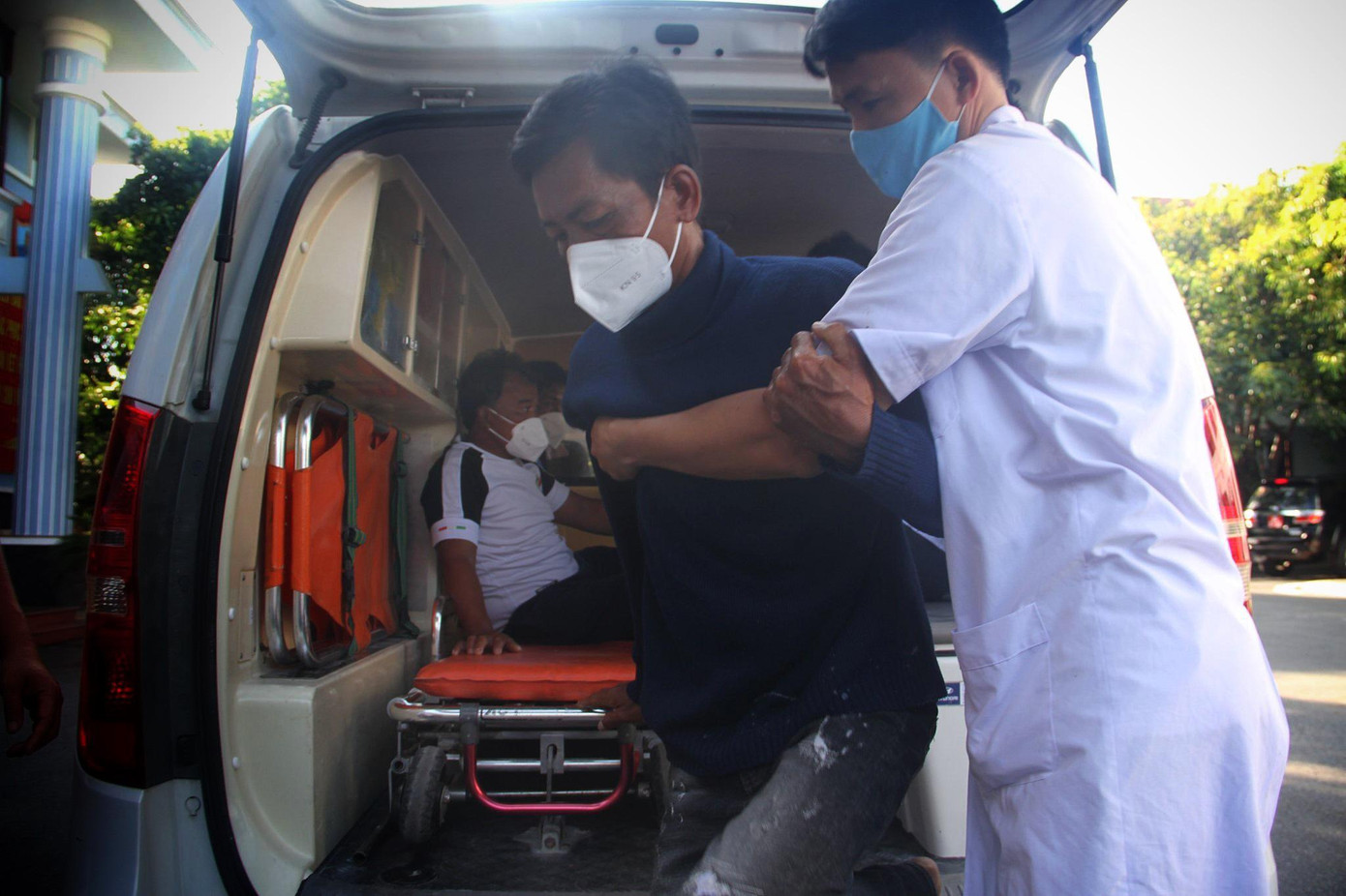 Lực lượng y tế dìu thuyền viên Bùi Văn Vinh xuống xe. Ảnh T.H