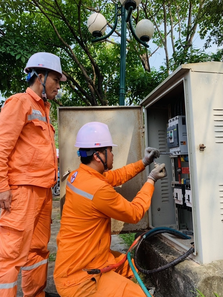 Công nhân ngành điện kiểm tra tủ phân phối Công nhân ngành điện kiểm tra tủ phân phối