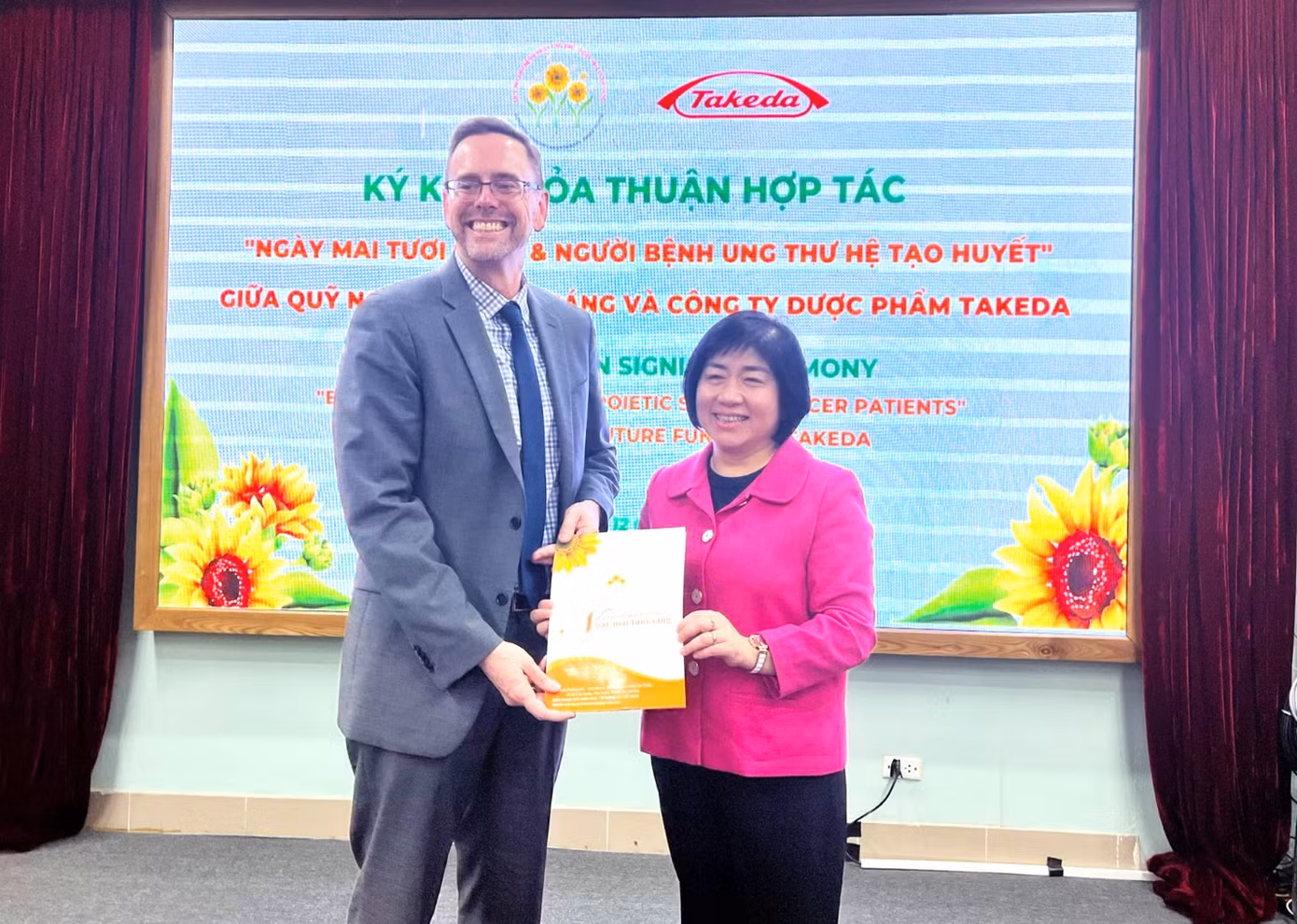 Ông Jeffrey Bishop, Quyền Trưởng đại diện Takeda tại Việt Nam (Trái), và PGS.TS Trần Thị Thanh Hương, Giám đốc Quỹ Ngày mai tươi sáng (Phải), tại Lễ ký kết thỏa thuận hợp tác chương trình hỗ trợ bệnh nhân ung thư máu năm 2023 Ông Jeffrey Bishop, Quyền Trưởng đại diện Takeda tại Việt Nam (Trái), và PGS.TS Trần Thị Thanh Hương, Giám đốc Quỹ Ngày mai tươi sáng (Phải), tại Lễ ký kết thỏa thuận hợp tác chương trình hỗ trợ bệnh nhân ung thư máu năm 2023