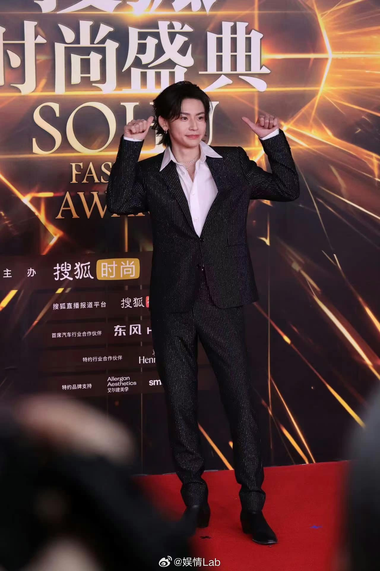 Tiểu Quỷ tạo điểm nhấn khi chọn suit đen với họa tiết kẻ sọc kim tuyến. Tiểu Quỷ tạo điểm nhấn khi chọn suit đen với họa tiết kẻ sọc kim tuyến.