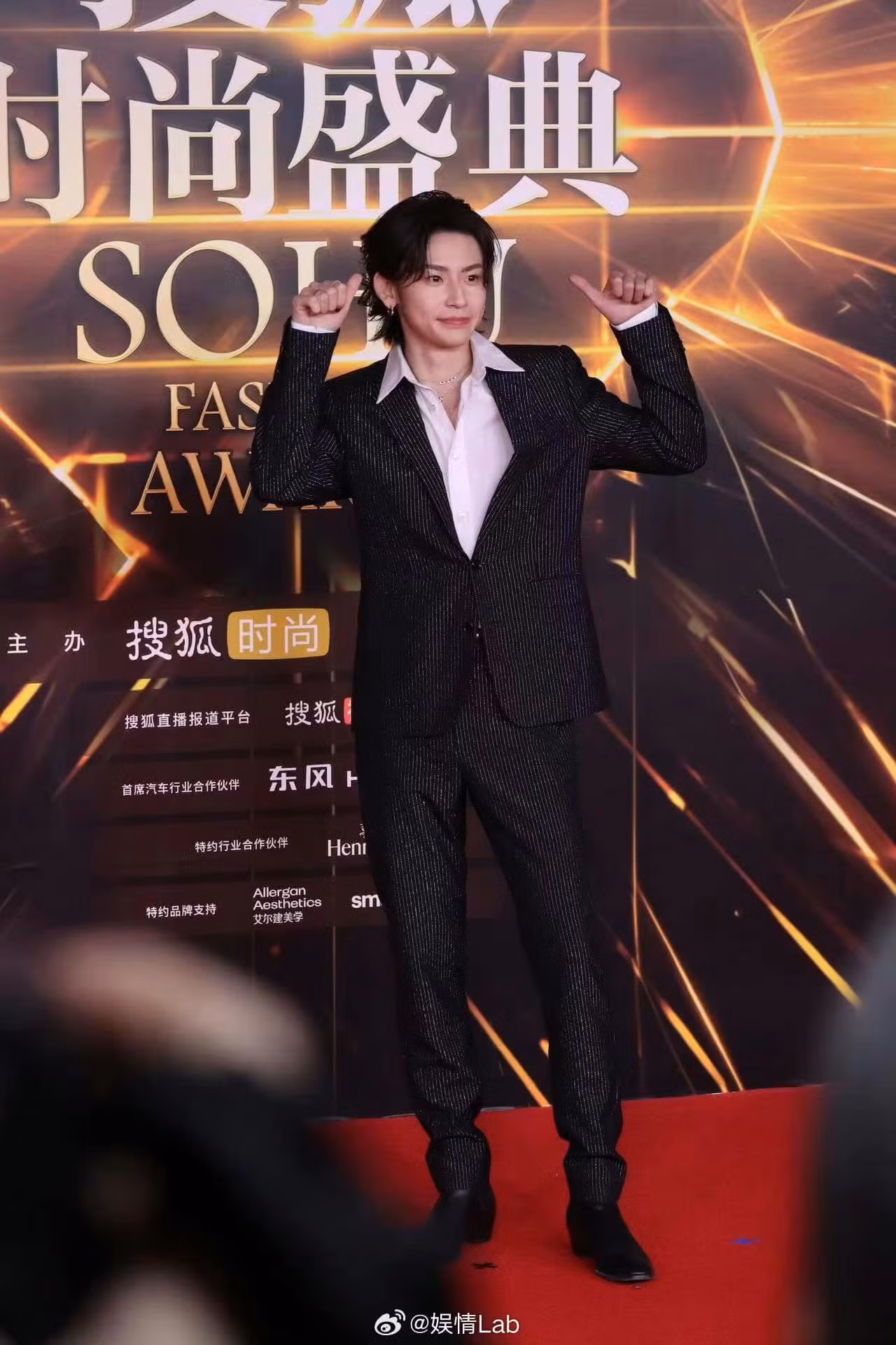 Tiểu Quỷ tạo điểm nhấn khi chọn suit đen với họa tiết kẻ sọc kim tuyến.