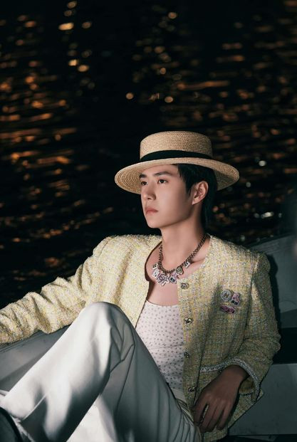 Chanel boy Vương Nhất Bác với áo khoác dạ tweed vàng nhạt cùng nón cói.