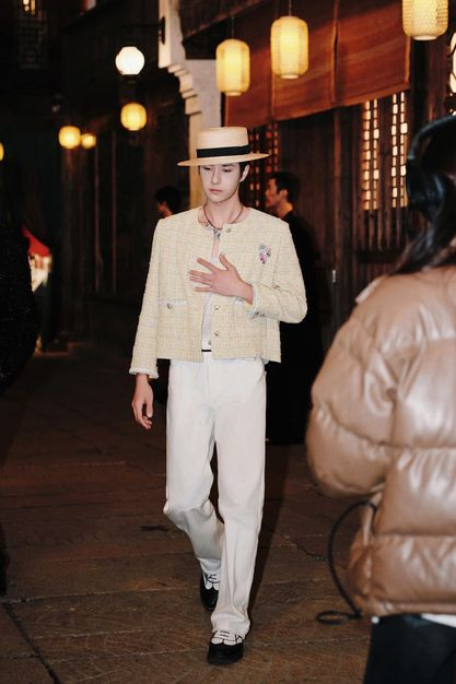 Chanel boy Vương Nhất Bác với áo khoác dạ tweed vàng nhạt cùng nón cói.
