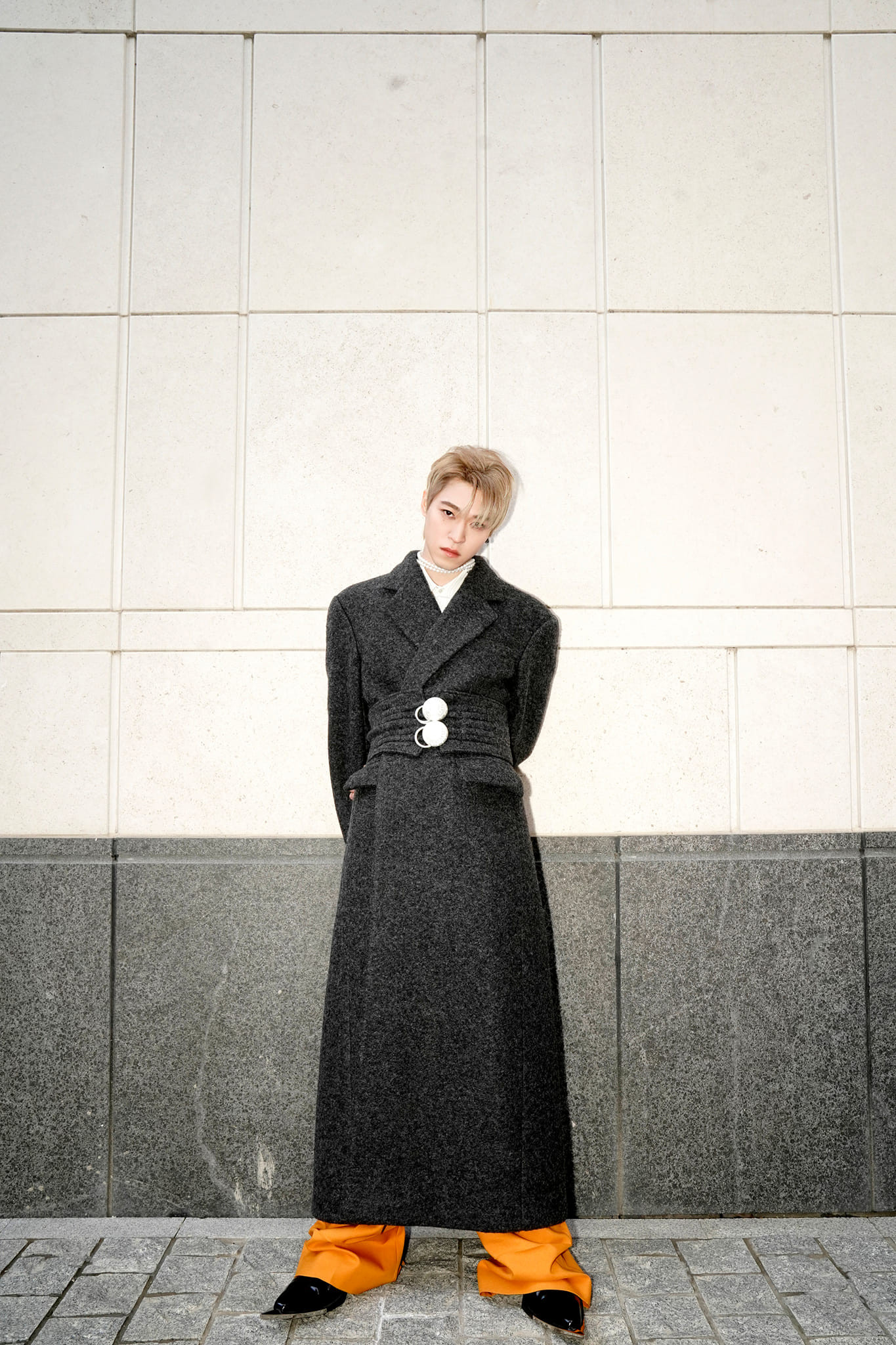 Santa phối màu ấn tượng với áo dạ dài, quần suông vàng. Phụ kiện vòng ngọc trai và giày mũi nhọn giúp diện mạo mỹ nam trở nên ấn tượng.