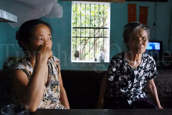 Bà Phạm Thị Hanh - mẹ em Đặng Minh Hậu kể hoàn cảnh gia đình với phóng viên. Hiện, cả gia đình bà đang ở nhờ nhà ông nội của Hậu. Ngồi bên cạnh bà Hanh là bà nội của Hậu - bị hỏng một mắt đã 30 năm nay, thường xuyên đau yếu, phải chăm sóc hàng ngày. Ngồi nghe chuyện, dù không còn minh mẫn, thỉnh thoảng, nước mắt của bà nội em Hậu lại rơi, thương cảm hoàn cảnh gia đình. Ảnh: Trường Phong