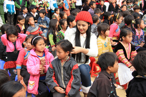 Ngọc Hân tết tóc cho một bé gái. Ảnh: Trường Phong. Hoa hậu Ngọc Hân ngồi cùng hàng và tết tóc cho một bé gái. Ảnh: Trường Phong