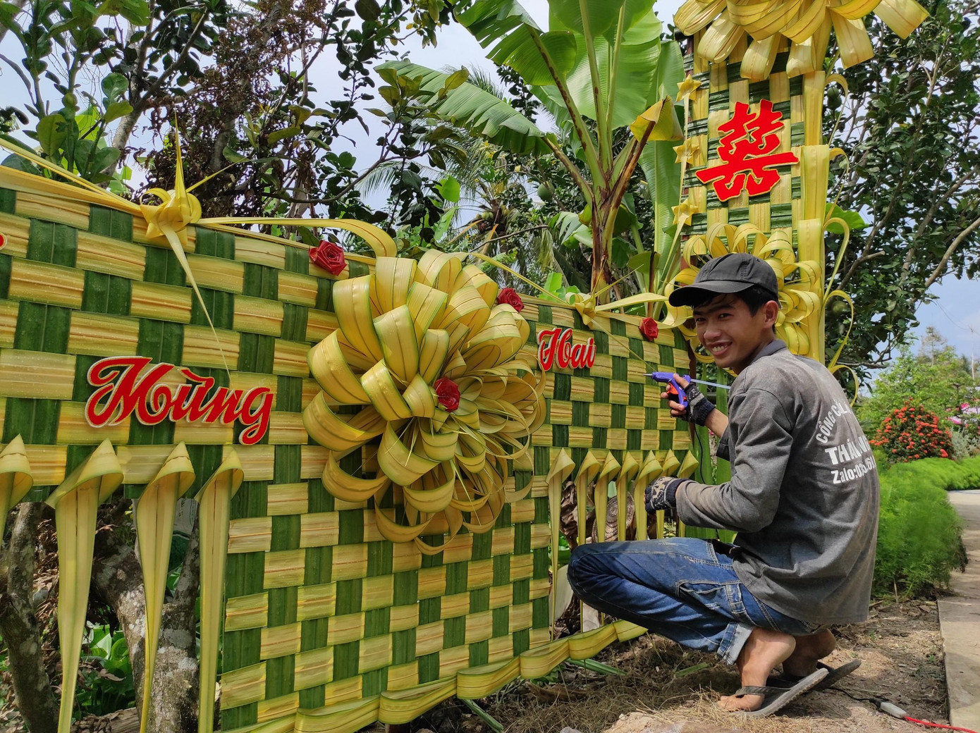Anh Thái đang hoàn thiện công đoạn gắn chữ, tạo điểm nhấn cho chiếc cổng cưới lá dừa vừa thực hiện. Ảnh: Hữu Huy Anh Thái đang hoàn thiện công đoạn gắn chữ, tạo điểm nhấn cho chiếc cổng cưới lá dừa vừa thực hiện. Ảnh: Hữu Huy
