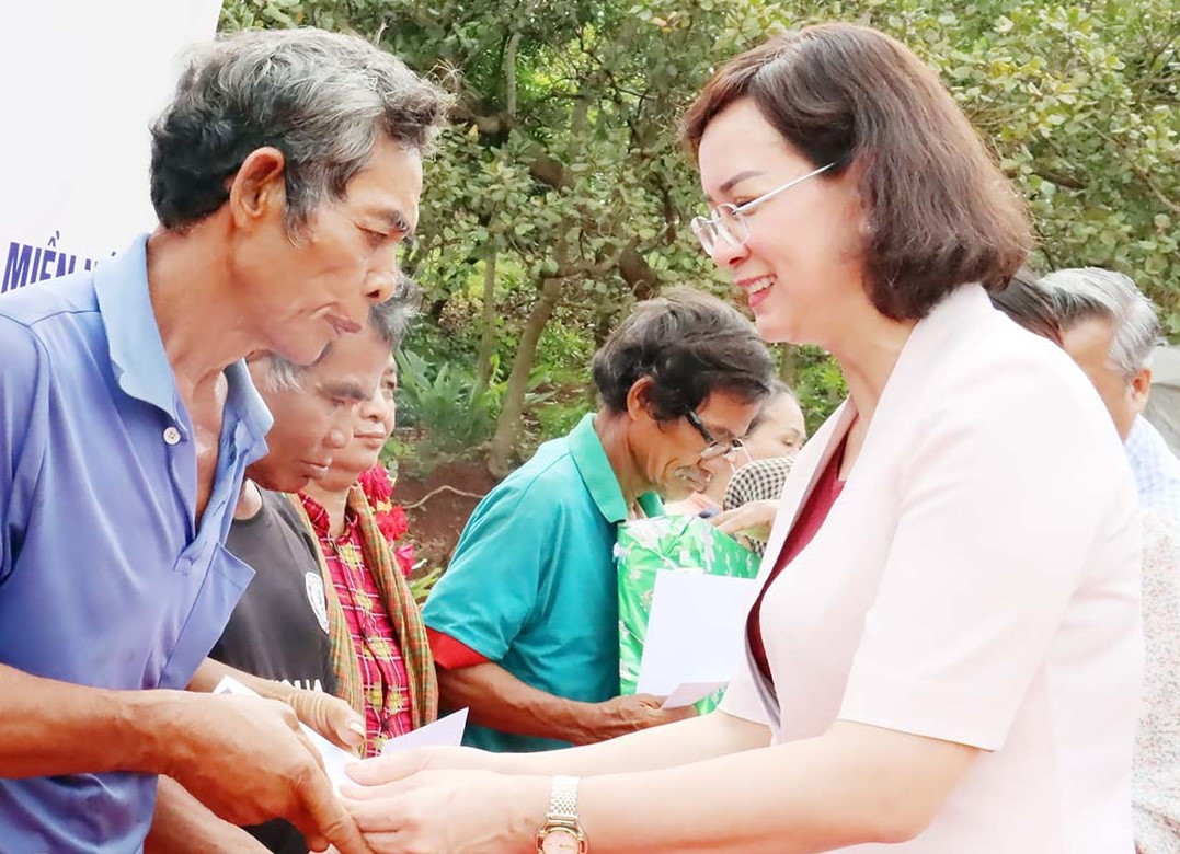 Phó Chủ tịch UBND tỉnh Bình Phước Trần Tuyết Minh (bìa phải) tặng quà cho bà con đồng bào dân tộc thiểu số có hoàn cảnh khó khăn