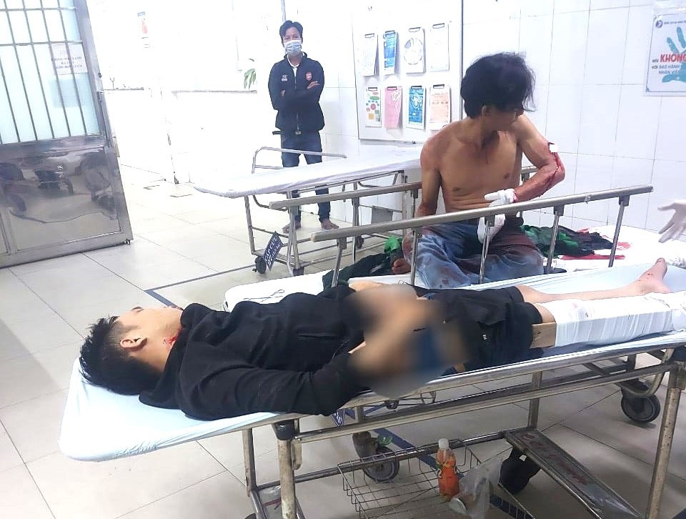 Tên cướp (áo đen) và tài xế xe ôm (cởi trần) đang được điều trị