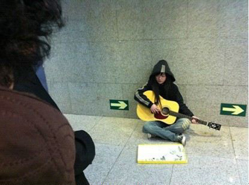 Hình ảnh cô gái xinh đẹp đánh đàn xin tiền bên lề phố khiến nhiều người động lòng