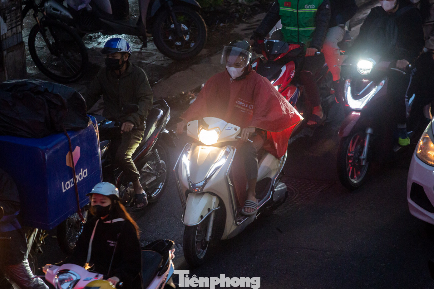 Mặc dù trời đã tạnh mưa nhưng nhiều người vẫn mặc áo mưa thay áo ấm trước những đợt gió rét.