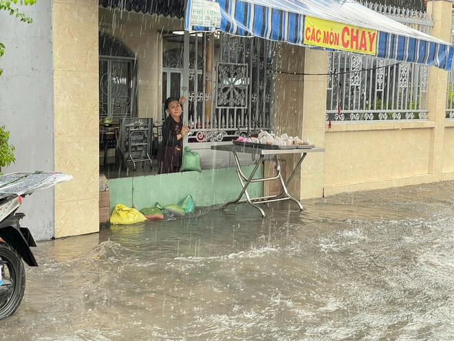 Người dân sống, buôn bán trong khu vực ngập phải ngăn nước tràn vào nhà bằng ván gỗ...