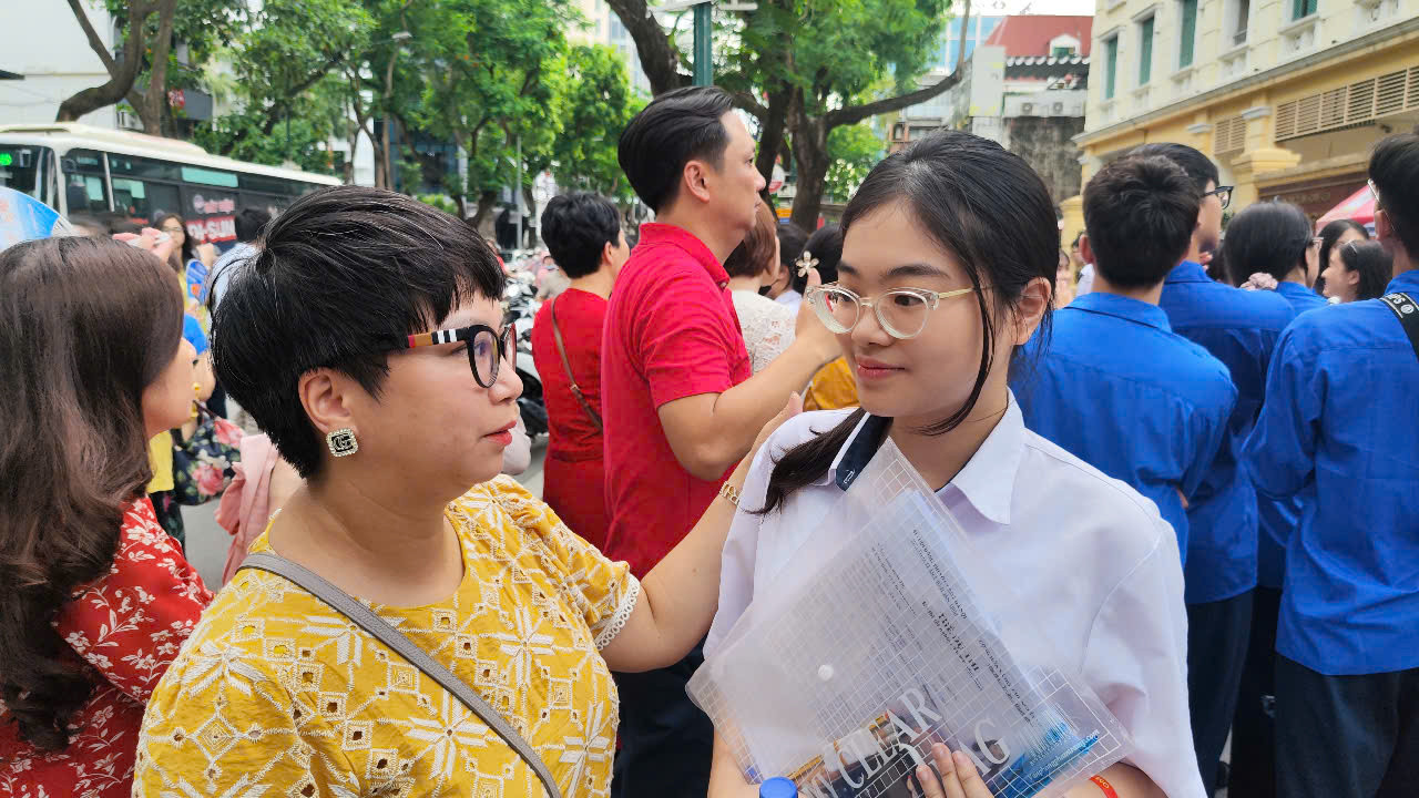 Chị Thu hỏi thăm con gái sau khi hoàn thành kỳ thi. Ảnh: Thúy Hằng. Chị Thu hỏi thăm con gái sau khi hoàn thành kỳ thi. Ảnh: Thúy Hằng.