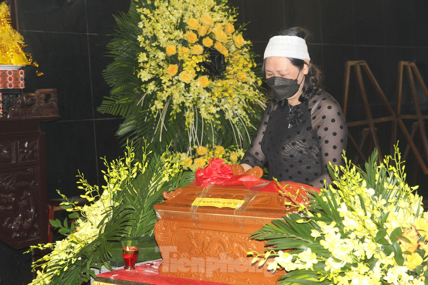 Bà Anh Thuý - vợ nhạc sĩ Hồng Đăng bên hài cốt của chồng.