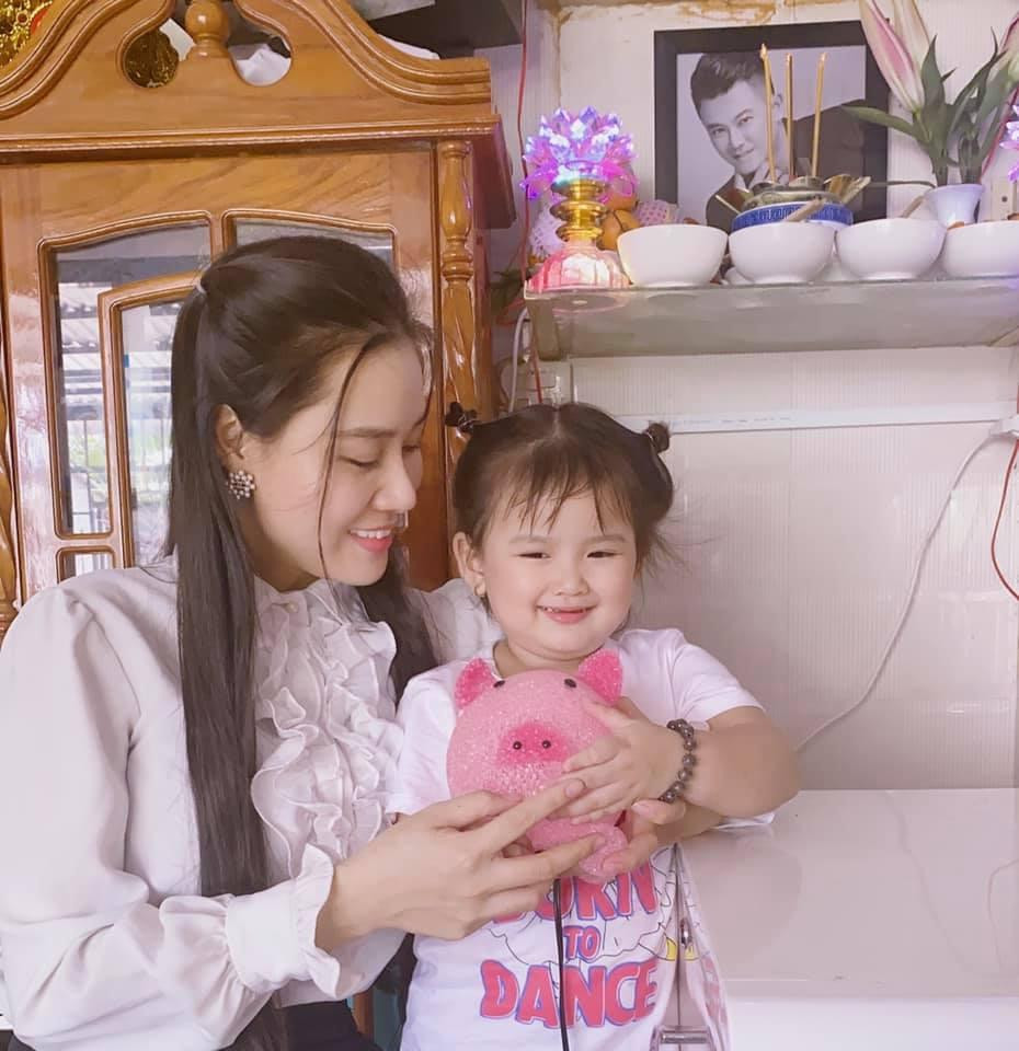 Bé Helen cười hạnh phúc ôm trong tay món kỷ vật của ba.