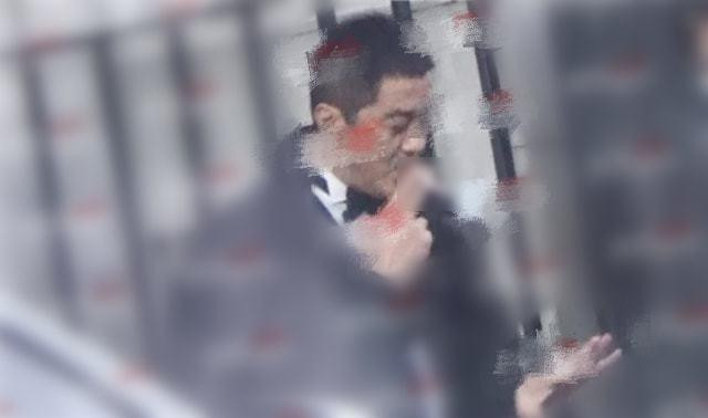 Lý Á Bằng nhìn ngắm nhẫn cưới ngoài studio.