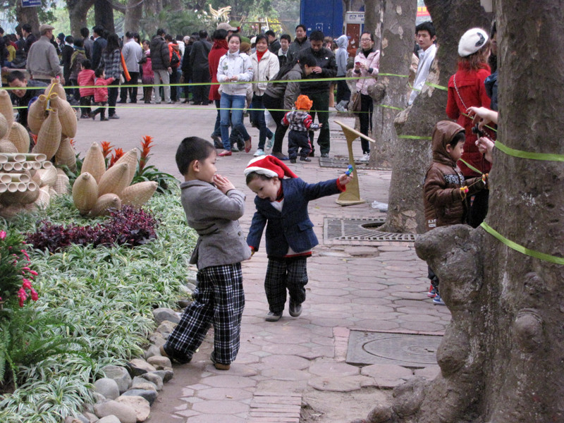 Trẻ nhỏ được bố mẹ, ông bà cho chui vào trong hàng rào để chụp ảnh