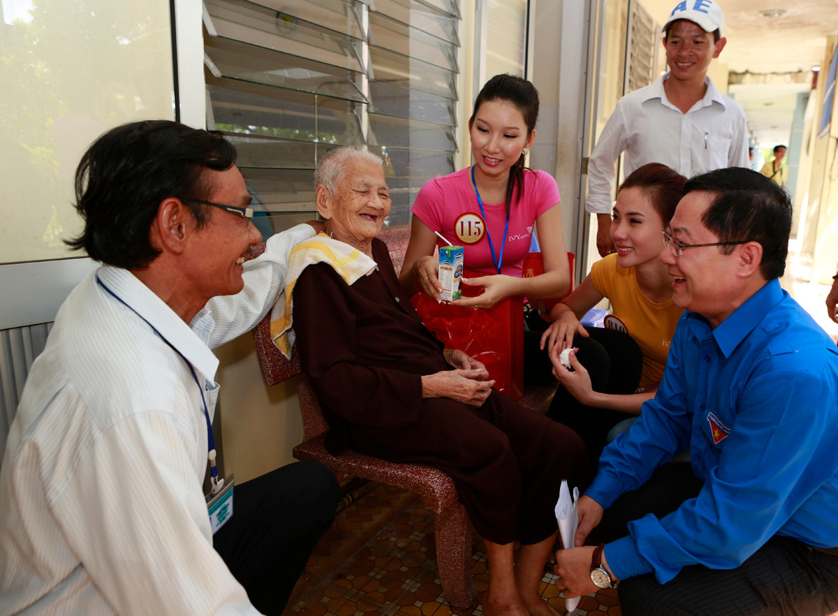 TBT báo Tiền Phong Lê Xuân Sơn cùng các thí sinh Hoa hậu thăm hỏi cụ Sửu, người đã 104 tuổi tại trung tâm Chăm sóc những người có công