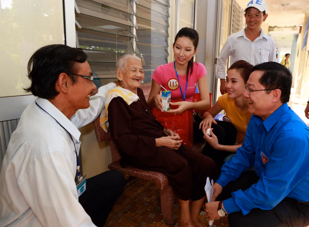 TBT báo Tiền Phong Lê Xuân Sơn cùng các thí sinh Hoa hậu thăm hỏi cụ Sửu, người đã 104 tuổi tại trung tâm Chăm sóc những người có công