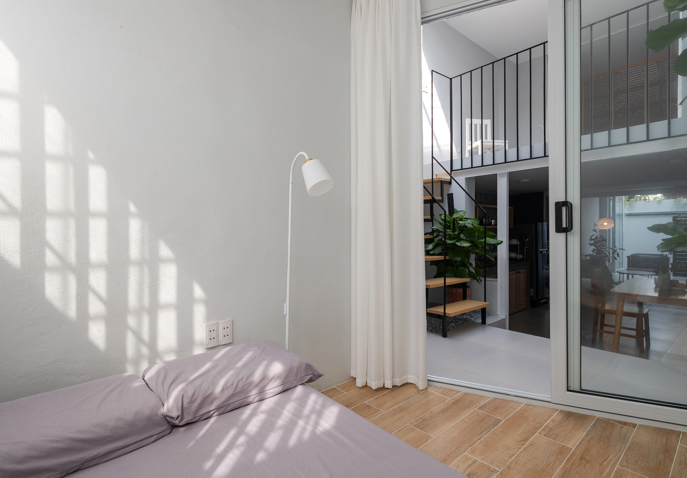 Nâng mái mới cao hơn tạo khoảng trống và giúp thông gió. Sân trước, sân sau và khoảng đệm giữa nhà được lợp bằng polycarbonate trong giúp ánh sáng tự nhiên tràn ngập khắp các khu vực trong nhà.