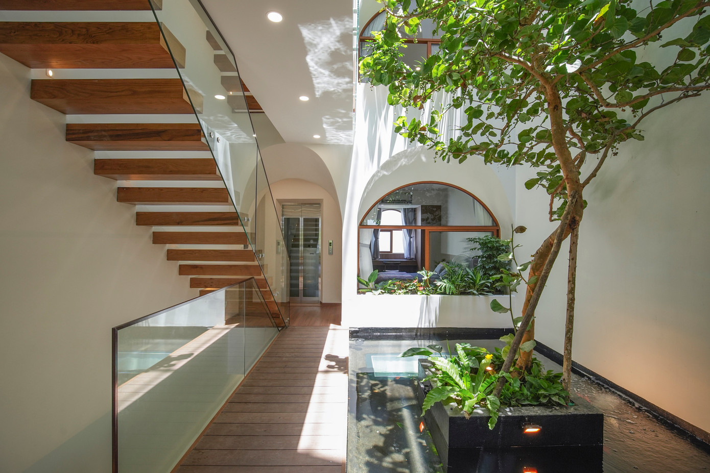 Việc làm bể cá cũng là một biện pháp vật lý để giảm nhiệt cũng như giải tỏa tâm lý cho người ở. Ở giữa bể cá, thay vì hoàn toàn bằng bê tông, KTS sử dụng đáy kính để mang lại nhiều ánh sáng tự nhiên hơn cho khu vực tiếp khách tạm thời ở tầng trệt, vì thế bể cá có chức năng giống như một chiếc bóng đèn để thắp sáng không gian.