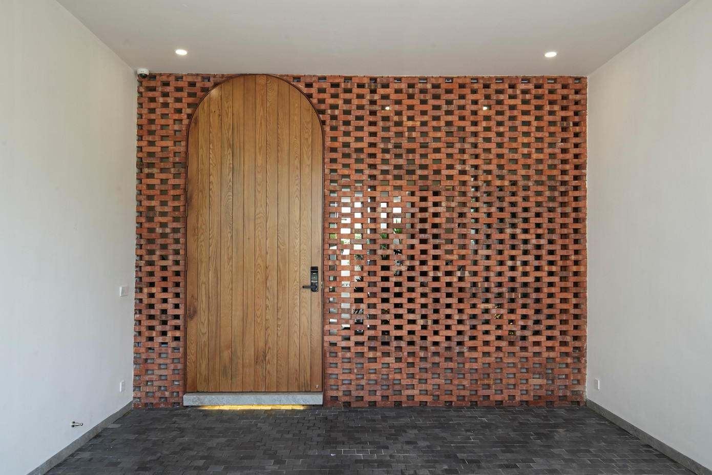 Ở cổng chính của ngôi nhà, KTS cũng sử dụng nhiều vật liệu địa phương như gạch nung, đá ong và kết hợp với cây xanh tạo nét độc đáo riêng.