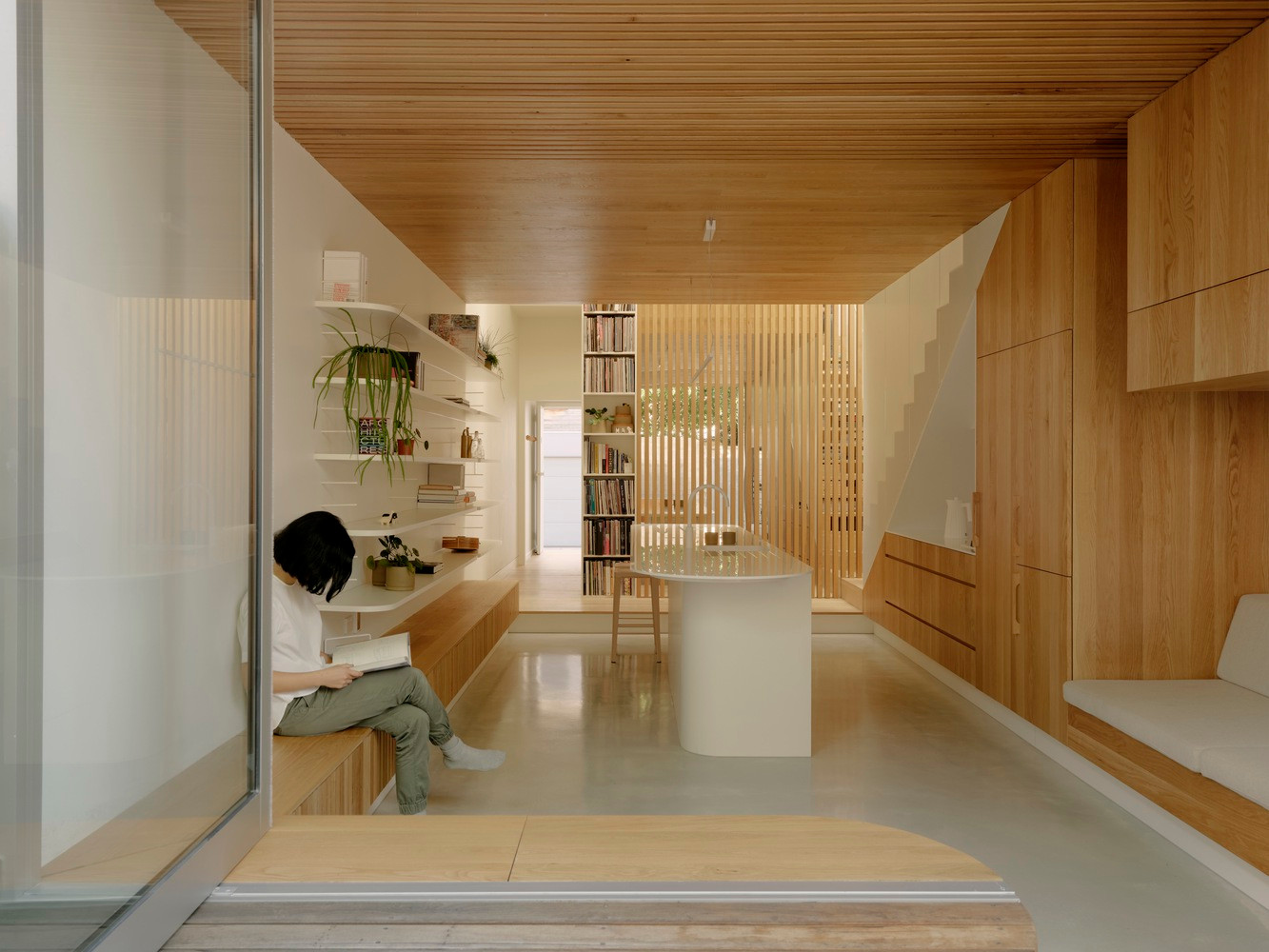 Đối diện với tủ bếp nấu là kệ sách và cây cảnh, bếp cũng chính là phòng khách của ngôi nhà. Đối diện với tủ bếp nấu là kệ sách và cây cảnh, bếp cũng chính là phòng khách của ngôi nhà.