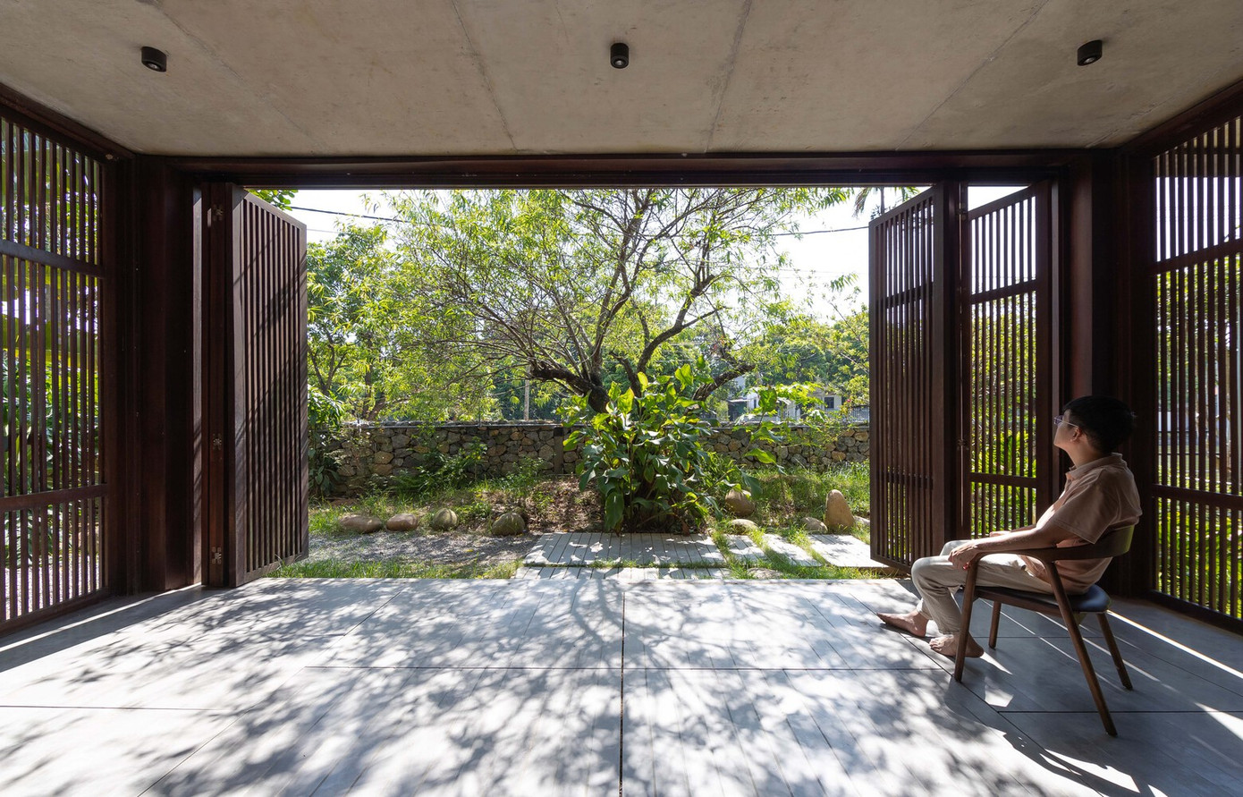 Biệt thự có mặt tiền dài với chiều sâu hạn chế, vị trí xây dựng khá gần với đường cơ sở của khu đất, dẫn đến diện tích cây xanh bị hạn chế. Do đó, KTS đã điều chỉnh cao độ và tạo trục cảnh quan kết nối khung cảnh xanh bên trong và bên ngoài khiến cả hai không gian trở nên thống nhất.