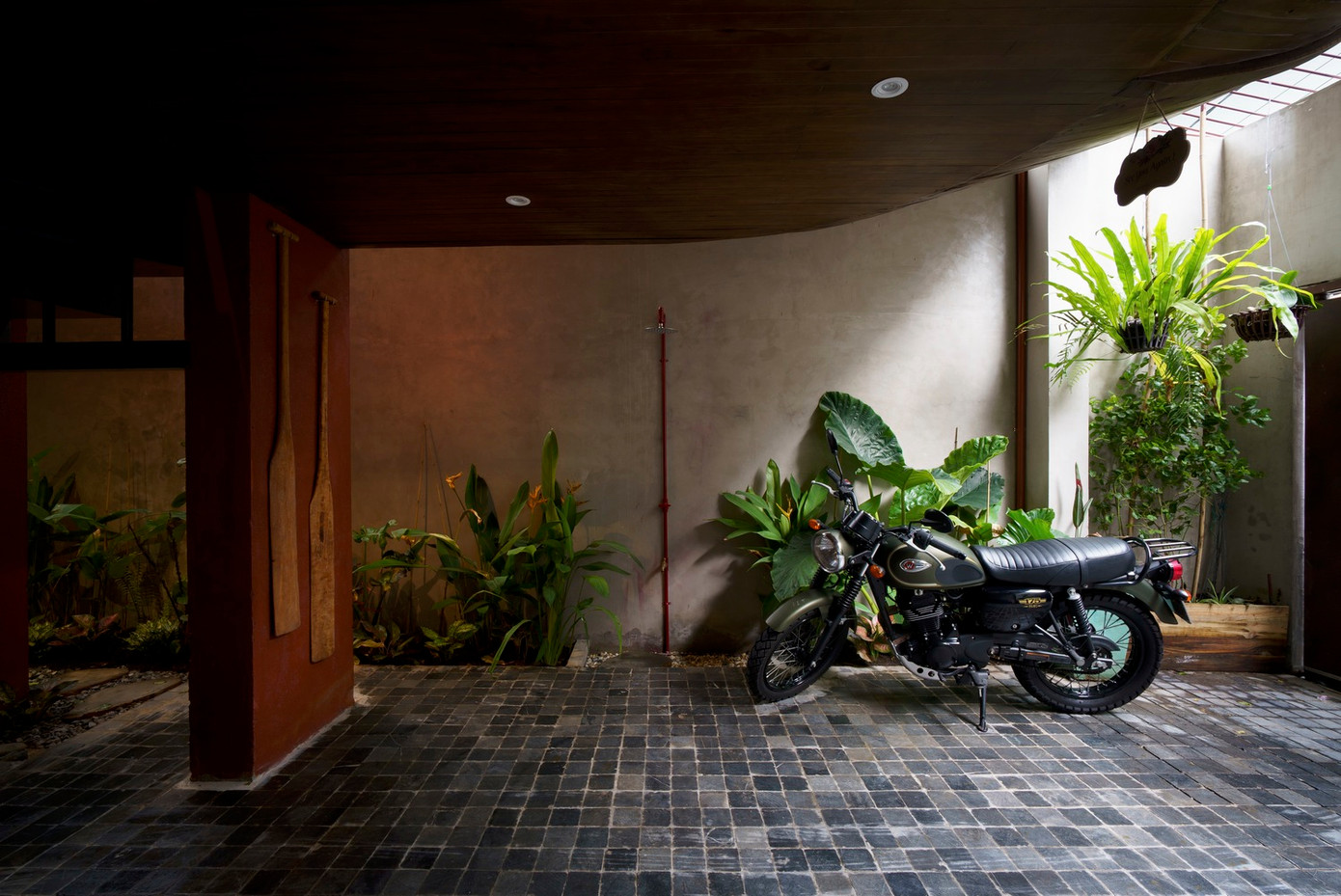 Tầng 1 gồm sân để xe và khu bếp ăn chung. Trong đó, kiến trúc sư thiết kế khu bếp ăn với không gian mở hoàn toàn mời thiên nhiên vào nhà.