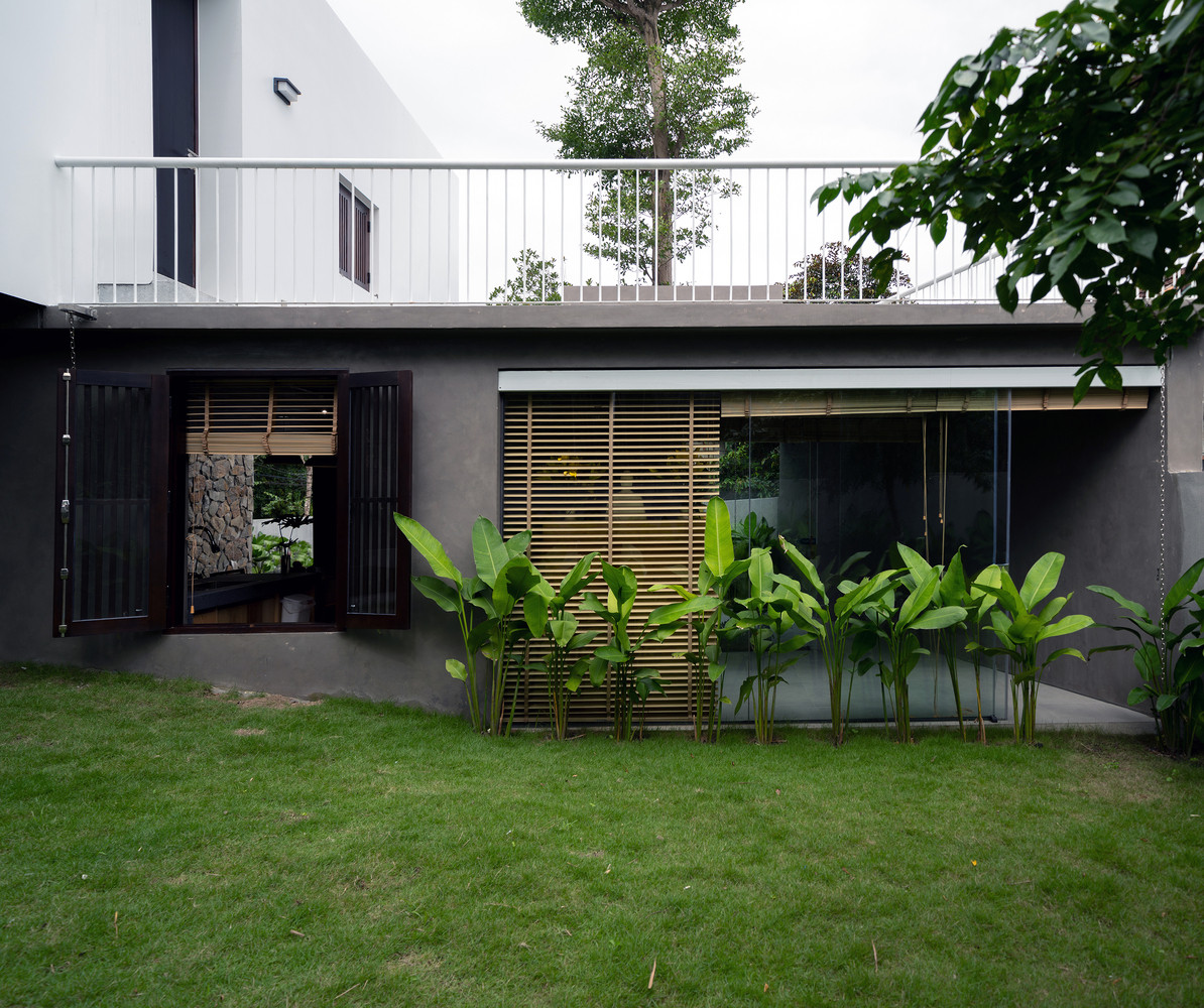 Mặt bằng tầng 1 được thiết kế với hình thức đơn giản nhất có thể, là phần nối tiếp theo chiều ngang từ tường rào, kéo dài theo chiều ngang khu đất, chia sân vườn thành 2 phần: Khu phía trước là lối vào với bãi đậu xe, bể bơi, tiệc ngoài trời. Diện tích phía sau là vườn trồng rau và cây ăn trái.