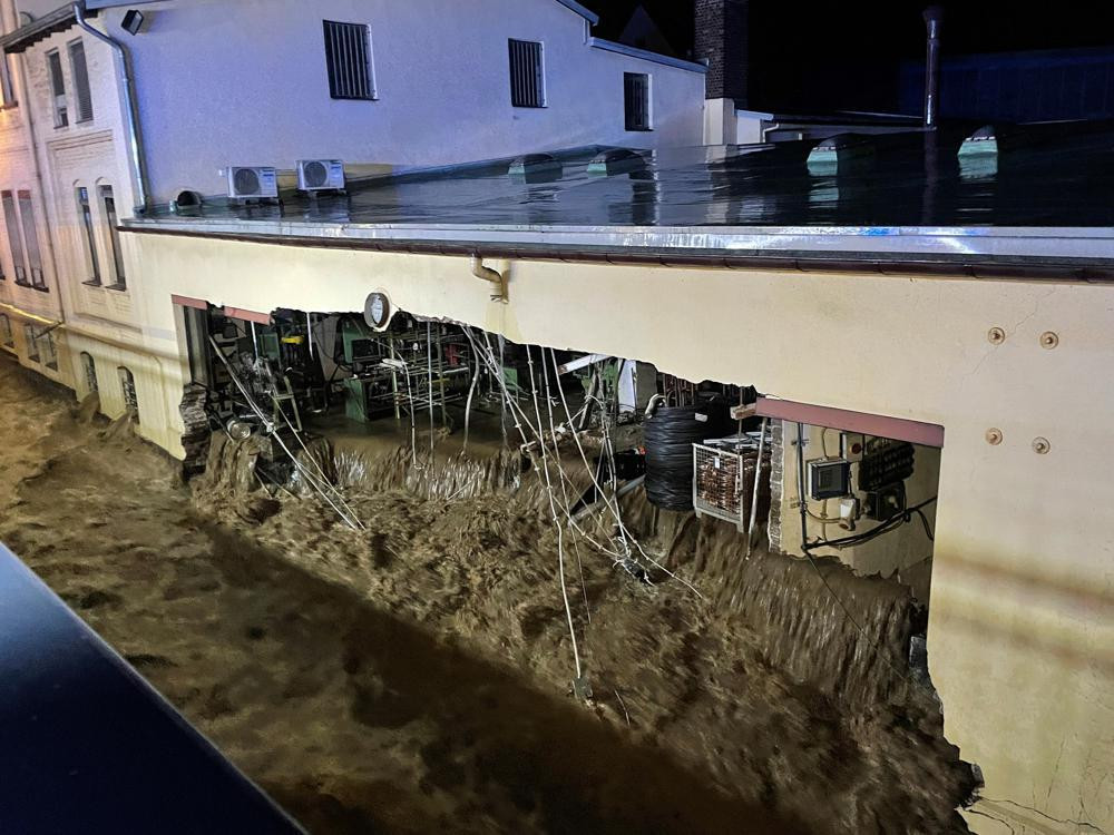 Nước lũ cuốn trôi tường nhà ở Hagen (Đức). Ảnh: AP