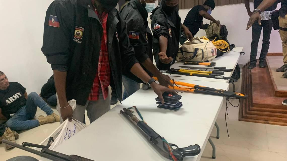 Cảnh sát Haiti cho các phóng viên xem một số cuốn hộ chiếu Colombia cùng một số tang vật gồm súng trường, dao rựa, bộ đàm, máy cắt bu lông, búa… Ảnh: Miami Herald Cảnh sát Haiti cho các phóng viên xem một số cuốn hộ chiếu Colombia cùng một số tang vật gồm súng trường, dao rựa, bộ đàm, máy cắt bu lông, búa… Ảnh: Miami Herald