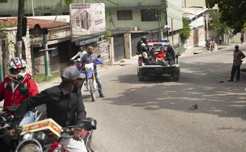 Các nghi phạm bị cảnh sát giải đi sau cuộc đột kích. Ảnh: AP Các nghi phạm bị cảnh sát giải đi sau cuộc đột kích. Ảnh: AP