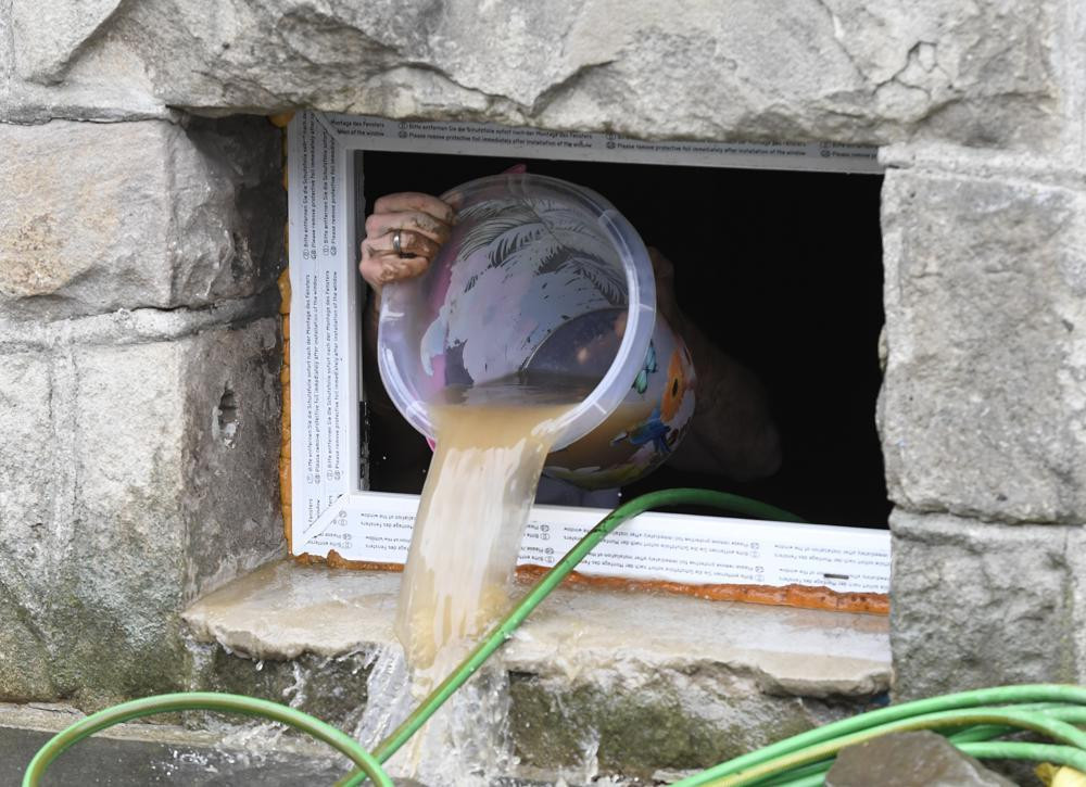 Người dân Hagen múc nước lũ đổ ra đường. Ảnh: AP