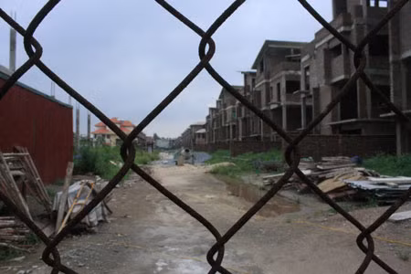 Bên trong hàng rào là máy móc nằm chỏng chơ